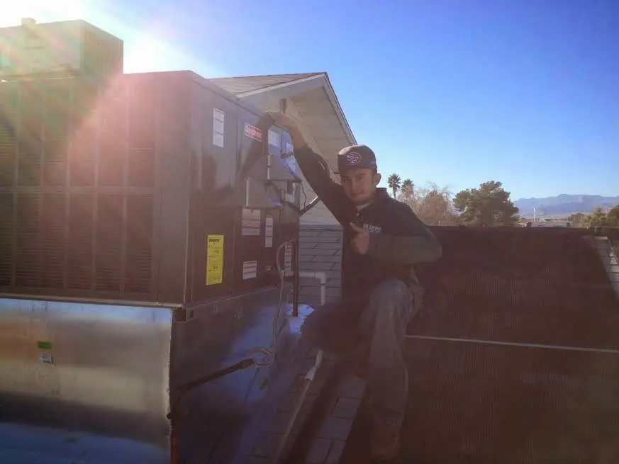HVAC technician performing HVAC Inspection on a rooftop unit in Clay